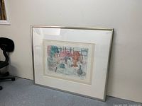 Framed abstract painting showing the entire artwork and frame leaning against a wall with surrounding furniture.