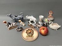 Group photo showing all miniature animals, Hummel plaque, decorative vase, pedestal bowl, birdhouse ornament, shell-shaped dish, and artificial apple