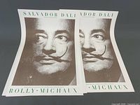 Two Salvador Dali gallery posters with prominent brown portrait and green text.