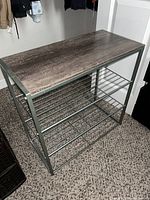 Image showing the metal shoe rack with wood top from an angle, displaying three lower metal racks and a wood top shelf.