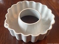 Top view of white ceramic fluted Bundt cake pan with a central tube and hanging hole.