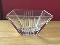 Front side view of square clear crystal dish showing stepped linear pattern on bottom sides