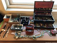 Overview of jewelry box with watches and jewelry pieces on table