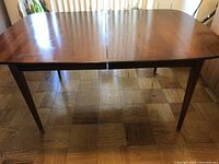 Front view of assembled table with leaf inserted showing tabletop and tapered legs