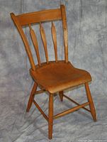 Light brown wooden dining chair with visible light staining and refinishing