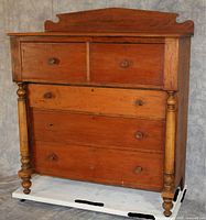 Front view of dresser showing two small drawers over three wide drawers with turned columns and feet