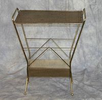 Front view of metal gold painted record rack, showing structure and shelving.