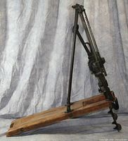 Side view of entire drill assembly on wooden base