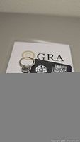 View of the 2ct certified moissanite ring with the GRA certification card showing.