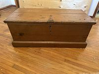 Front view of the antique blanket box showing the keyhole and edges of the lid.