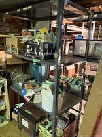 Metal shelving unit holding various boxes and household items in basement setting