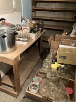 Basement table with pressure canner cooker and boxes of canning jars
