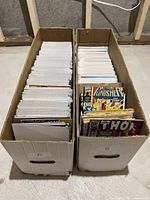 Two white long boxes labeled A and B filled with bagged and boarded comics, plus loose comics at front