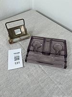 Photo of both the desk calendar and the ink and pen stand together on a surface with MaxSold lot card.