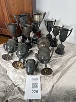 Lot of 13 silver plated trophies displayed together showing variations in size and base presence and condition.