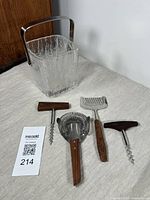 Front view of Hoya crystal ice bucket and five bar tools displayed on a white surface.