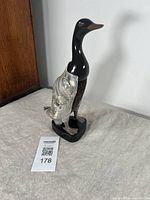 Front side view of duck shaped clothes brush showing black neck and polished head with marbled wings and natural hair brush area on the body.