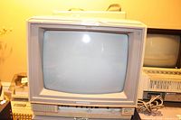 Photo showing the full front view of the beige Commodore 1802 CRT monitor with the screen off, highlighting the unit's style and physical condition including power cord.
