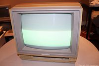 Front view of the Commodore 1802 CRT monitor powered on with screen lit up.