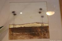Close-up of gold toned abstract picture with brown and gold layers and tall stems.