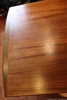 Close-up of the wooden table top showing wood grain and surface marks including water stains.