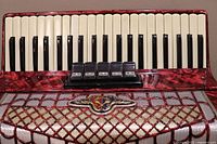 Front view of red marbled accordion keyboard and register buttons