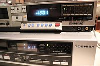 Front view of Sony Betamax SL-2300 and Toshiba VCR V-400C showing power on displays and control panels.