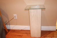 Side view of the natural stone base with glass top showing overall height and structure.