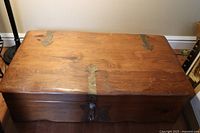 Top view of wooden chest showing metal hardware and wood grain
