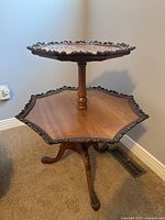 Full view of table showing upper and lower tiers, scalloped edges, and tripod base
