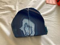 Top-down view of two blue agate geode halves placed together showing the polished, symmetrical matching surfaces and the central crystalline formation.