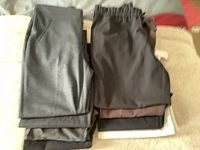Top view of folded pants in dark colors including black and grey showing fabric texture and pockets.