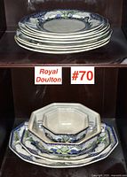 Stack of dinnerware plates viewed from side and top, showing Royal Doulton Art Nouveau pattern with floral and Greek key borders.