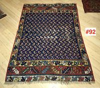 Angled top-down shot of full rug showing overall layout, border and central field.