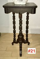 Full front angle view of antique spool table showing rectangular top, scalloped apron, and the legs made from stacked wooden thread spools.