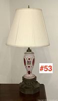 Full view of Bohemian glass table lamp with pleated fabric shade and dark ornate metal base
