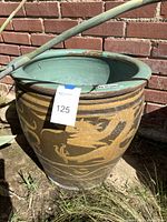 Planter exterior view showing Asian dragon design on brown body with green interior