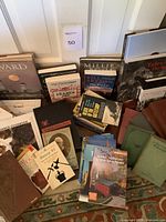 Wide view of varied antique and vintage books, showing titles like Millie's Bread Book, Tales of Mystery and Imagination, and Joe Constance's Trading Book.