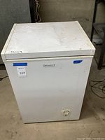 Full view of the white Emerson chest freezer showing overall condition and handwritten measurements on top.