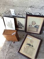 Photo showing four framed law judge prints and a wooden urn placed on concrete floor with wall background, highlighting worn condition and sizes.