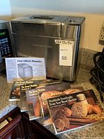 Full view of the Hamilton Beach Artisan Bread Maker with manuals and four bread recipe books displayed in front.