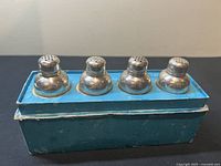 Four sterling silver salt/pepper shakers in original blue box, showing front side and top perforated lids