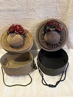 Two vintage velvet floral hat boxes, one tan and one dark brown, both open showing interiors, with rope handles.