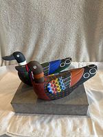 Pair of colorful hand carved and hand painted wooden Korean wedding ducks showing detailed feather paintwork and form, placed on a gray block base.