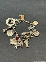 Top view of the charm bracelet showing multiple silver charms and one gold Birks charm