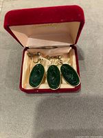Vintage Art Nouveau green glass molded intaglio earrings and brooch set inside a red velvet jewelry box with satin lining.