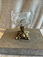Front view of vintage cut crystal bowl on ornate brass pedestal base showing detailed cut patterns and base design