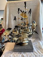 Front view of vintage carved horn and bone maritime ship model with detailed rigging on display base.