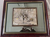 Full view of framed silver relief art showing the outdoor scene and mirrored border.