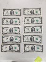 Front sides of ten sequential $2 US banknotes showing Thomas Jefferson's portrait and serial numbers.